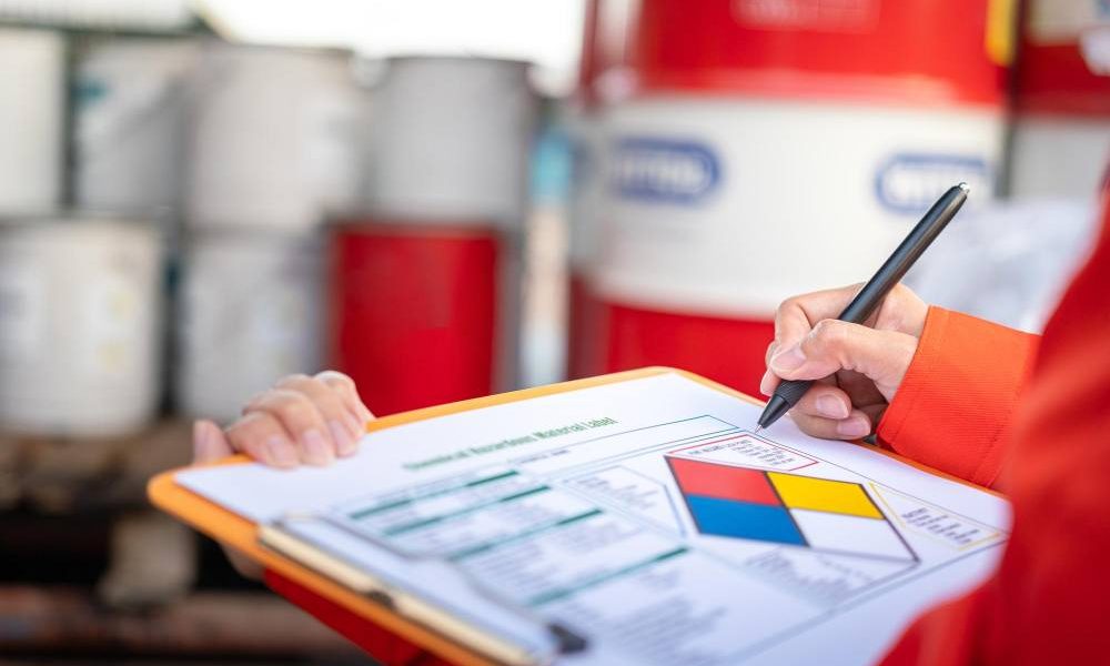 Regulatory Affairs Specialist che verifica una scheda di dati di sicurezza (SDS) e la documentazione REACH